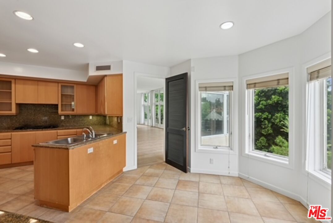 10351 Wilshire Boulevard, Unit PH1 Los Angeles, CA 90024 - Photo 22 of 23 a kitchen with stainless steel appliances granite countertop a stove a sink and a refrigerator