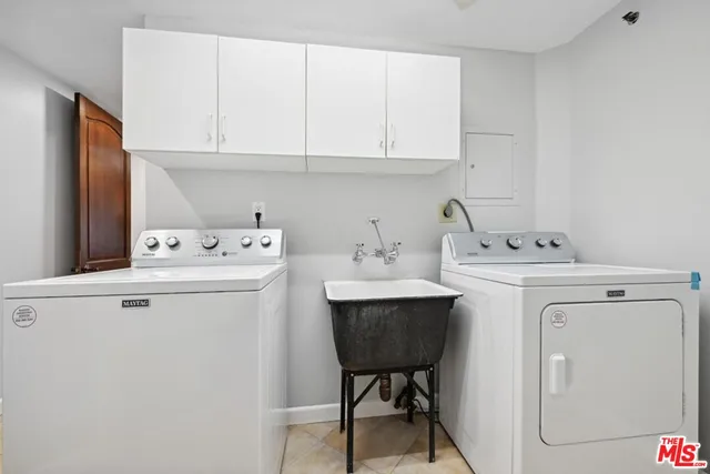 a utility room with cabinets washer and dryer