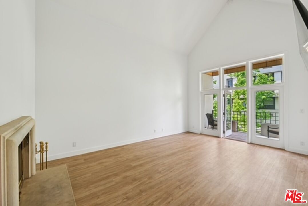 10351 Wilshire Boulevard, Unit PH1 Los Angeles, CA 90024 - Photo 10 of 23 a view of an empty room with wooden floor and a window