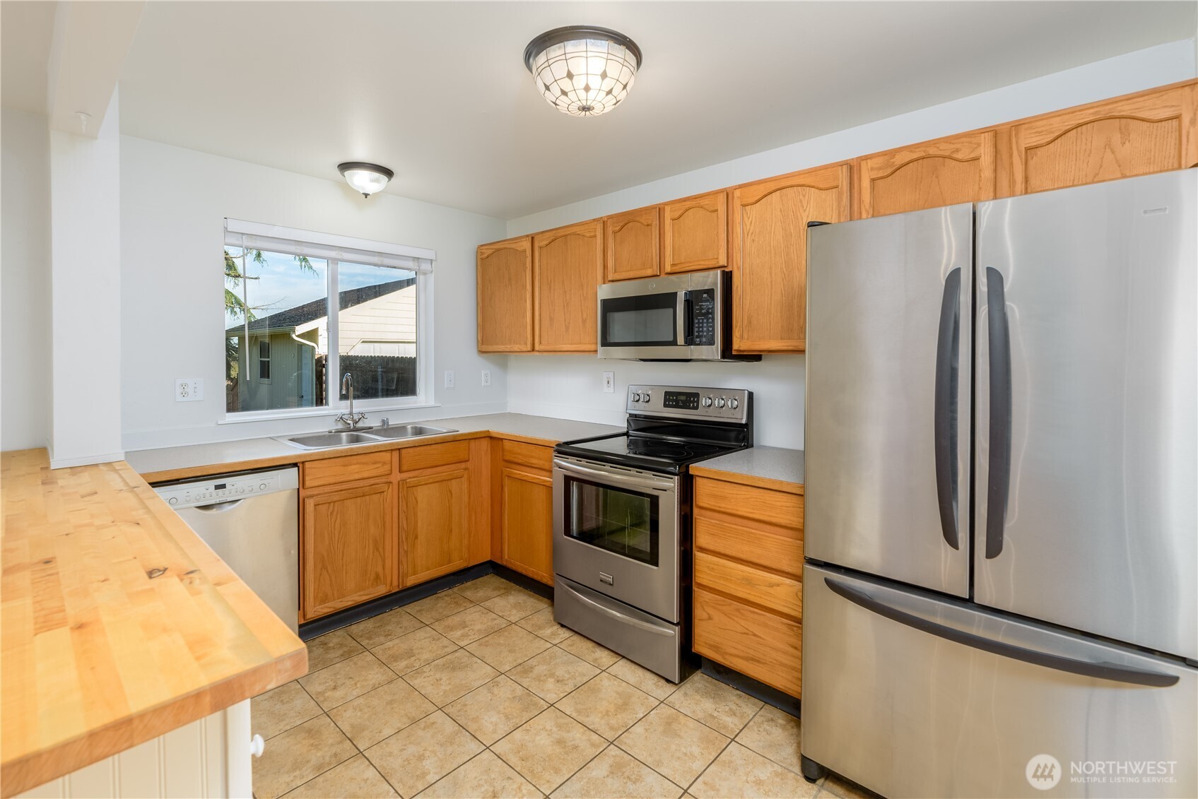 131 Alpine Loop Sequim, WA 98382 - Photo 12 of 40 a kitchen with stainless steel appliances granite countertop a refrigerator sink and microwave