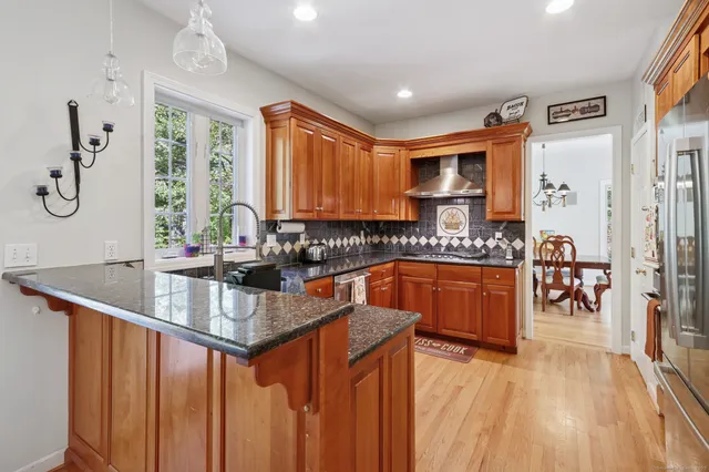 a kitchen with stainless steel appliances granite countertop a sink stove and refrigerator
