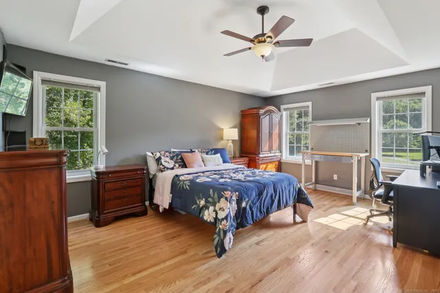 a bedroom with a bed and wooden floor