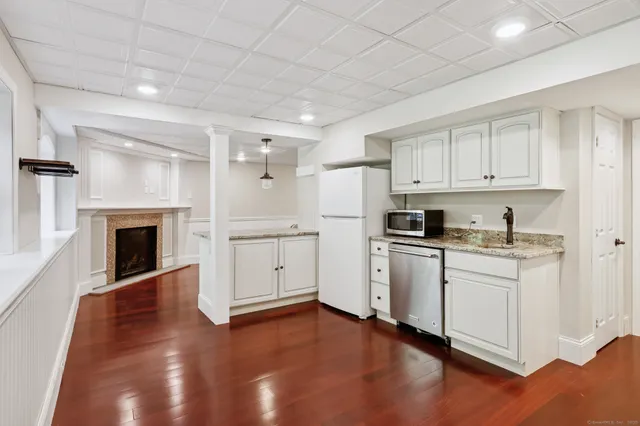 a kitchen with granite countertop white cabinets and white appliances