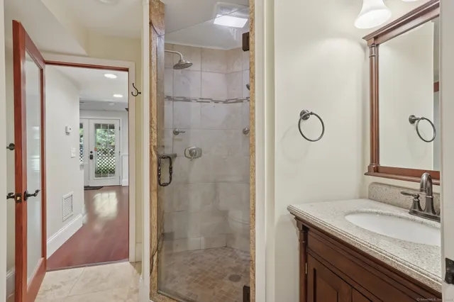 a bathroom with a granite countertop sink shower and a mirror