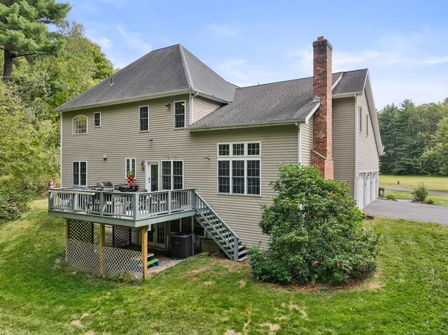 a view of house with a yard and deck