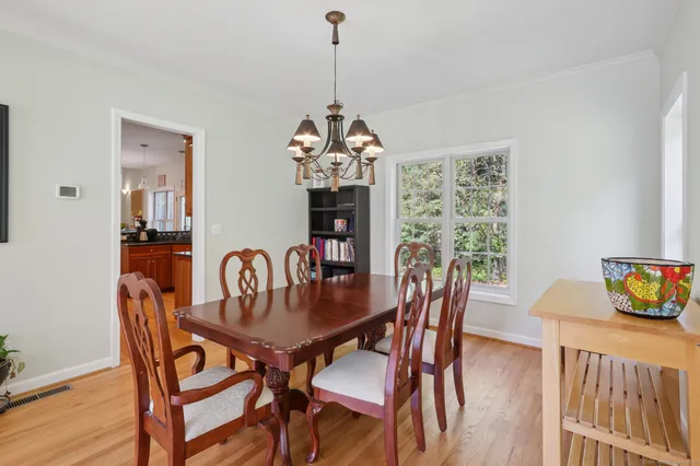 a dining room with furniture a chandelier and wooden floor
