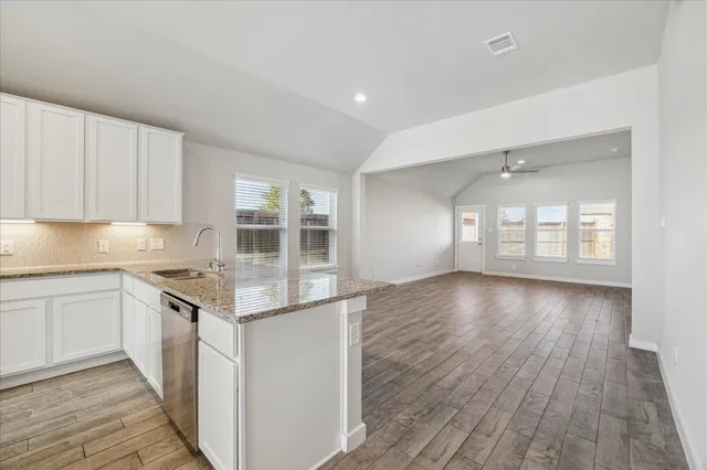a kitchen with granite countertop a stove and cabinets