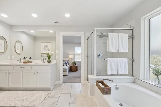 a spacious bathroom with a tub sink and mirror