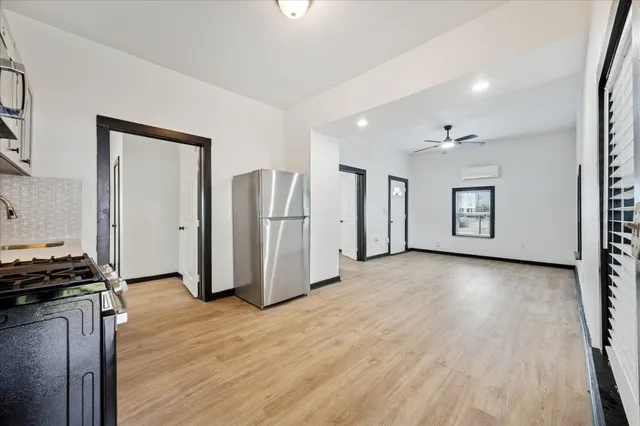 a view of a kitchen with refrigerator and wooden floor