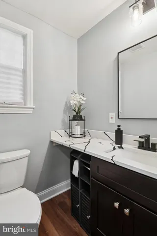 a bathroom with a granite countertop toilet sink and mirror