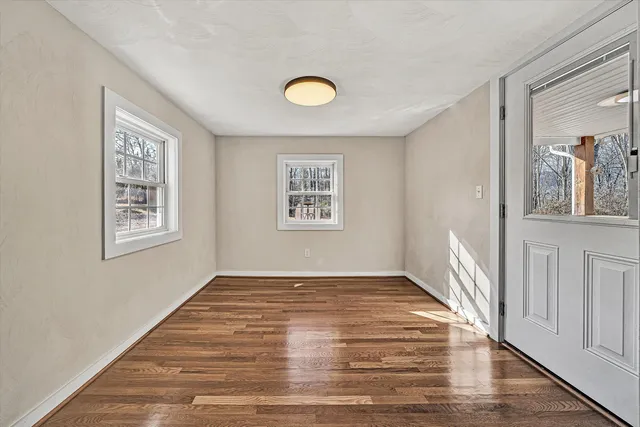 a view of a livingroom with wooden floor and a window