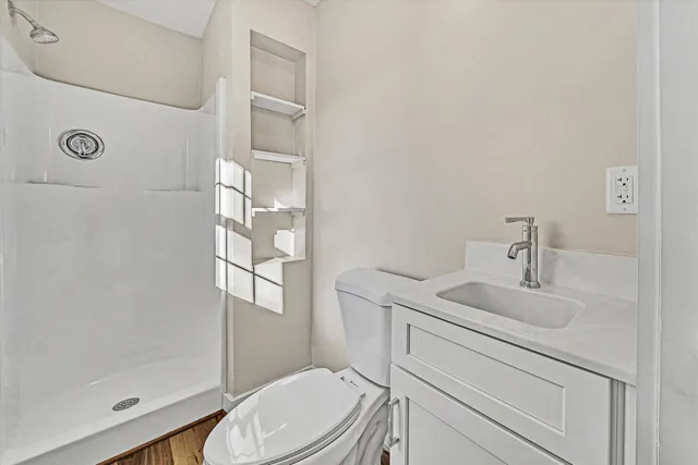 a bathroom with a sink a toilet and shower