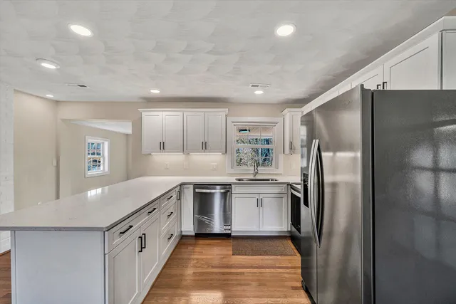 a kitchen with stainless steel appliances granite countertop a refrigerator and a sink