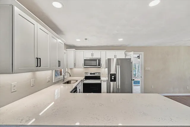 a large white kitchen with cabinets and stainless steel appliances