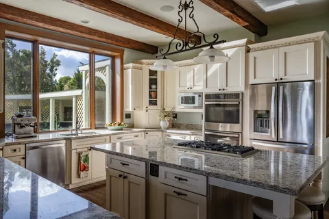a kitchen with stainless steel appliances granite countertop a sink a stove and a refrigerator