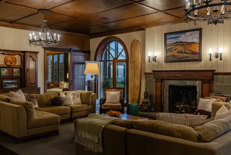 a living room with furniture a chandelier and a fireplace