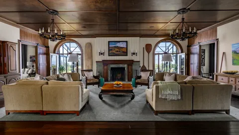 a living room with furniture a fireplace and a chandelier