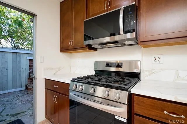 a kitchen with stainless steel appliances granite countertop a stove a sink and a microwave