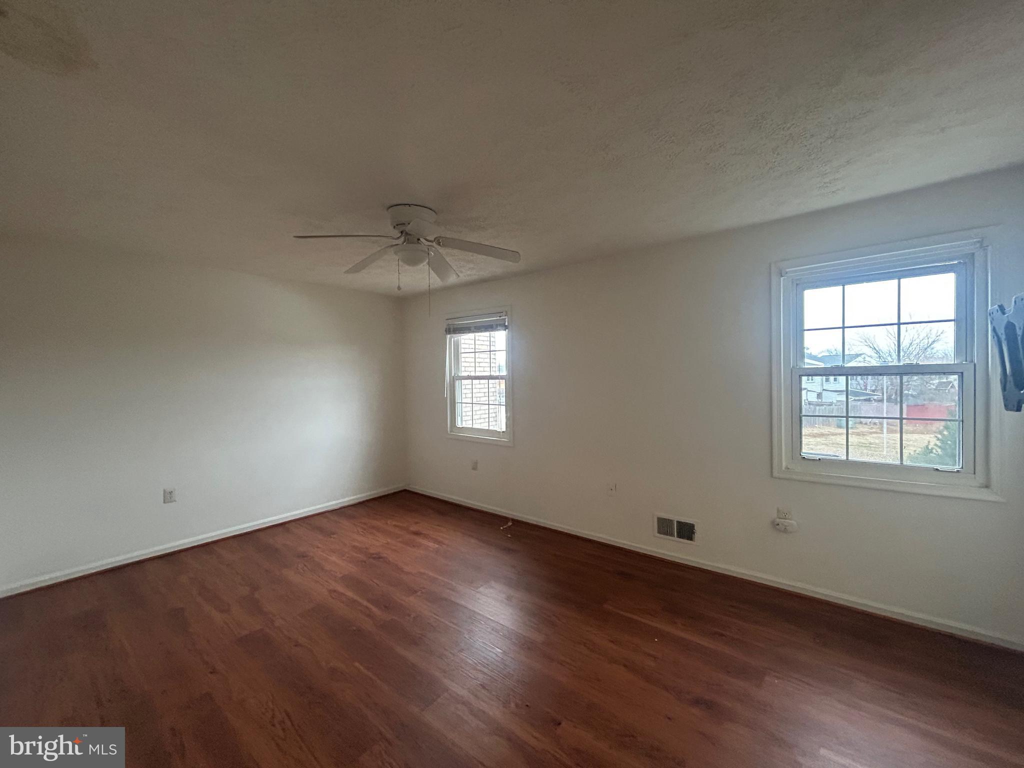 10177 Irongate Way Manassas, VA 20109 - Photo 17 of 25 an empty room with wooden floor chandelier fan and windows