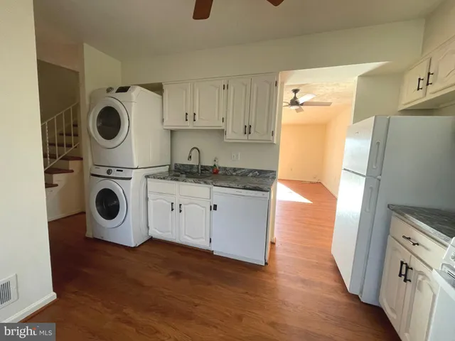 a kitchen with stainless steel appliances granite countertop a refrigerator a microwave and cabinets