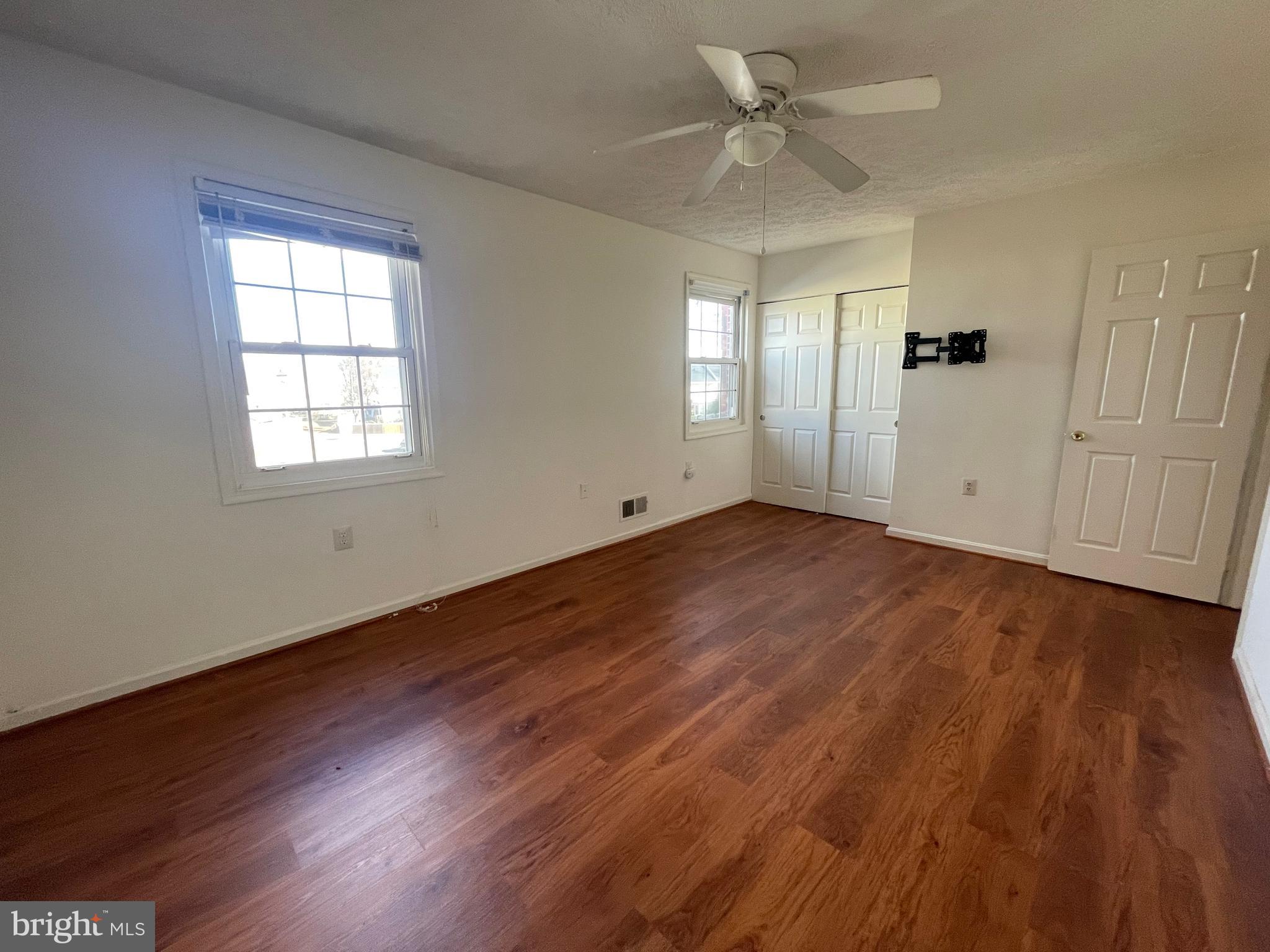 10177 Irongate Way Manassas, VA 20109 - Photo 9 of 25 an empty room with wooden floor chandelier fan and windows