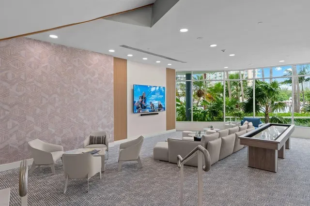 a living room with furniture and a view of kitchen