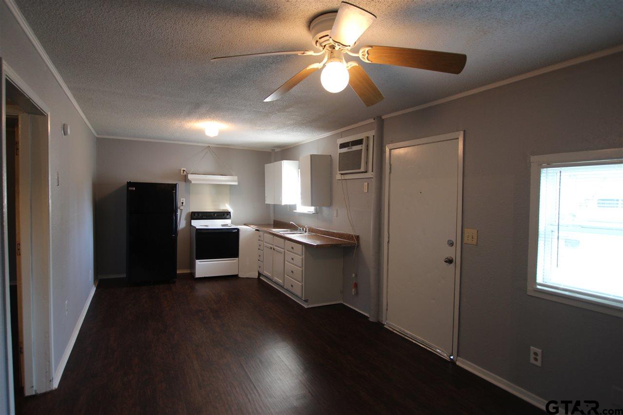 4229 Old Chandler Road, Unit B Tyler, TX 75702 - Photo 16 of 17 a kitchen with a refrigerator and a chandelier