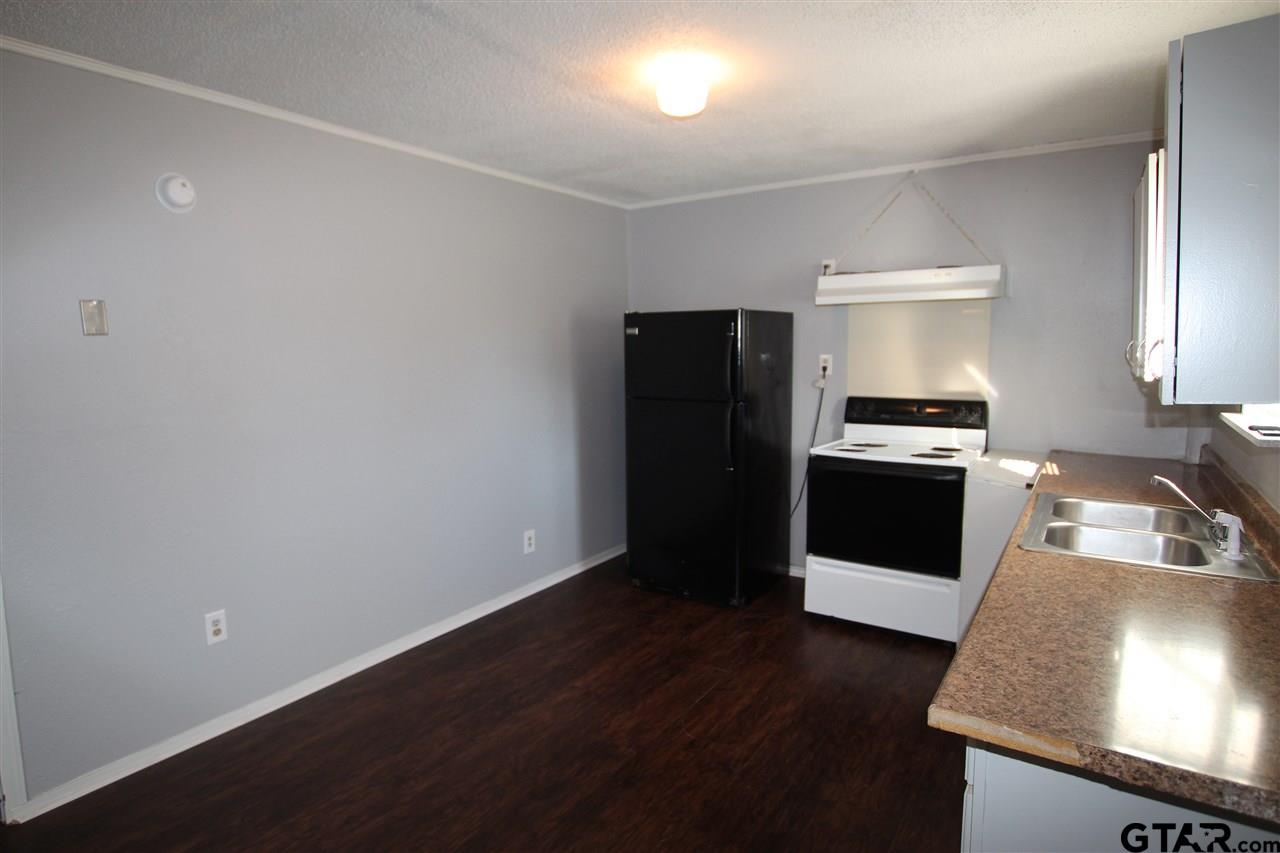 4229 Old Chandler Road, Unit B Tyler, TX 75702 - Photo 17 of 17 a kitchen with granite countertop a refrigerator sink and stove