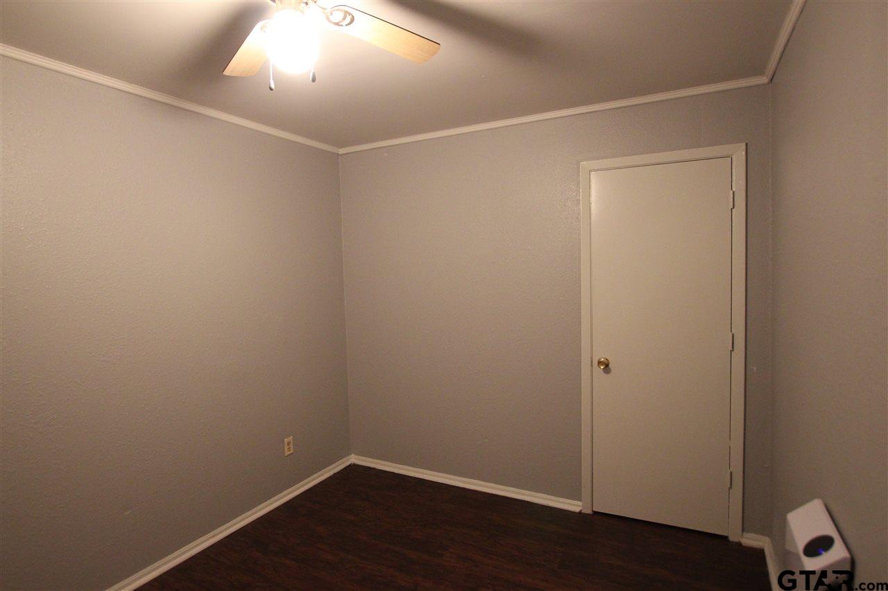 4229 Old Chandler Road, Unit B Tyler, TX 75702 - Photo 2 of 17 an empty room with wooden floor and white walls