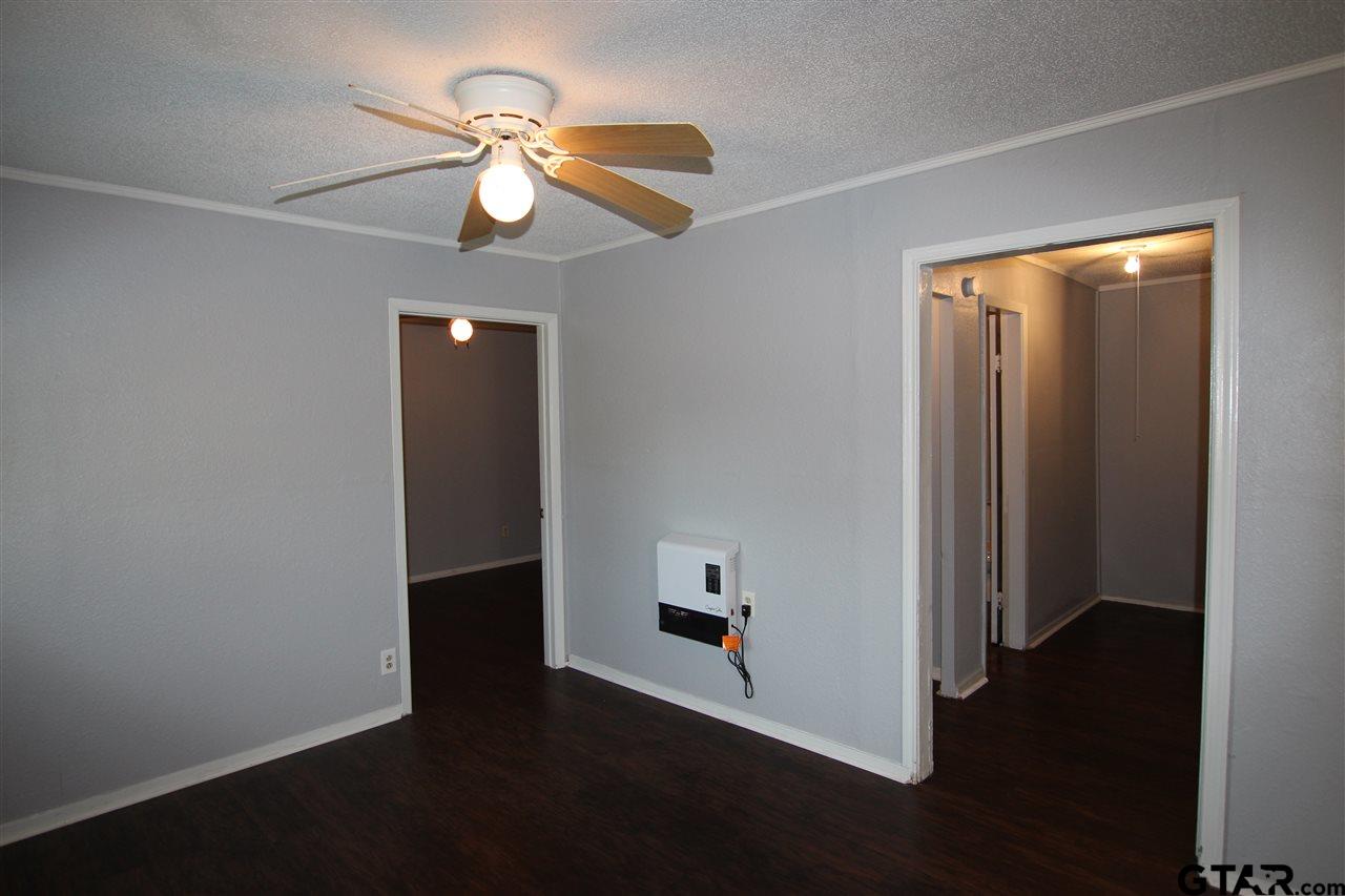 4229 Old Chandler Road, Unit B Tyler, TX 75702 - Photo 3 of 17 an empty room with wooden floor fan and windows