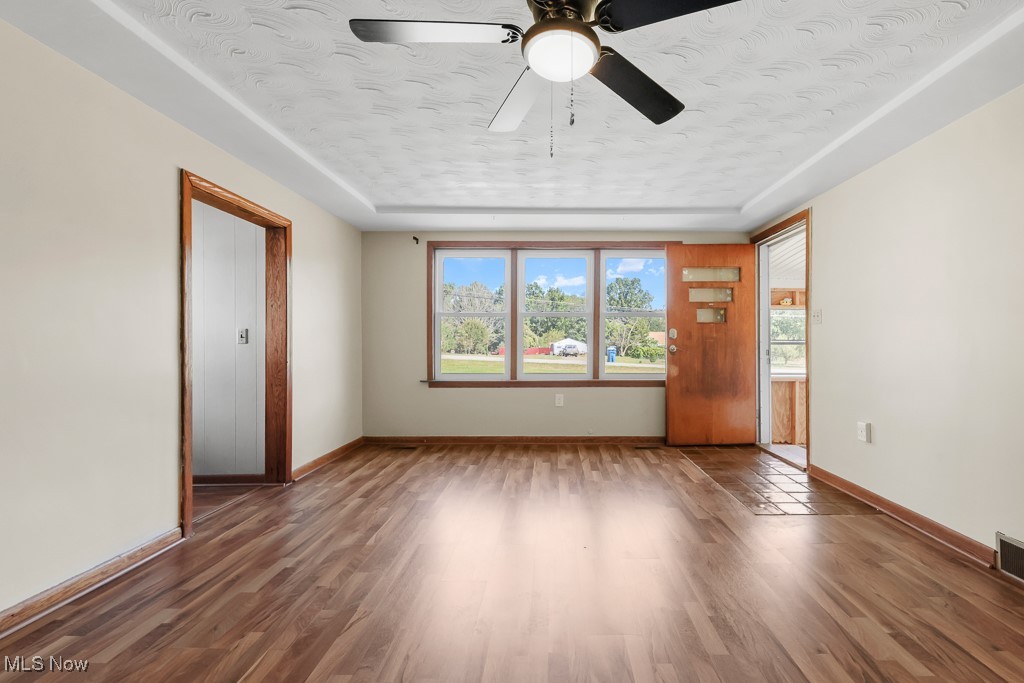 1702 Far View Road Akron, OH 44312 - Photo 7 of 49 Living room featuring wood finished floors, a textured ceiling, ceiling fan, and a raised ceiling