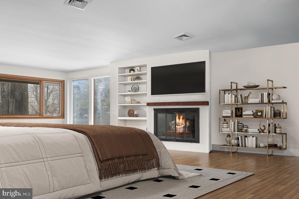 1112 General Saint Claire Road Washington Crossing, PA 18977 - Photo 18 of 34 a bedroom with a bed a flat screen tv and a fireplace