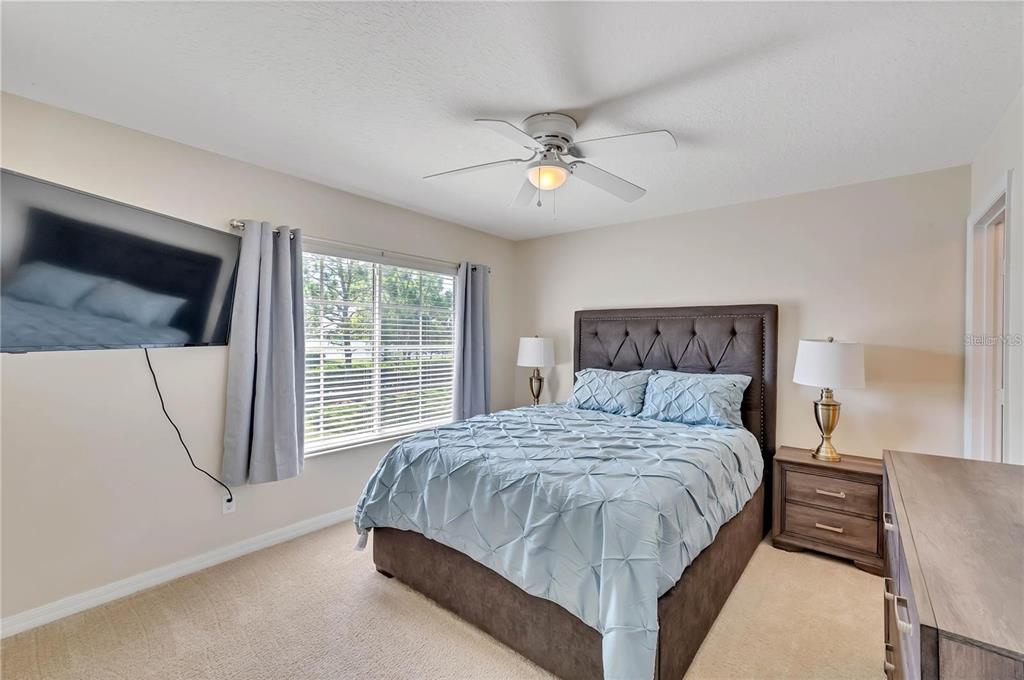 280 Cape Harbour Loop, Unit 101 Bradenton, FL 34212 - Photo 13 of 35 a bedroom with a large bed and a chandelier