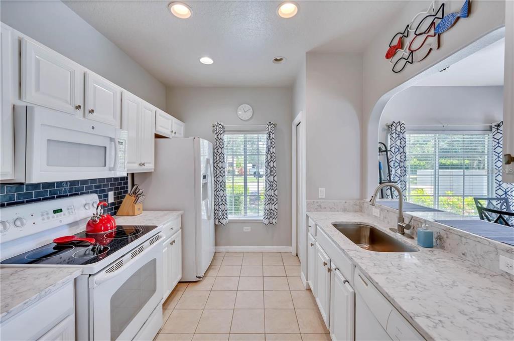 280 Cape Harbour Loop, Unit 101 Bradenton, FL 34212 - Photo 10 of 35 a kitchen that has a sink and a stove