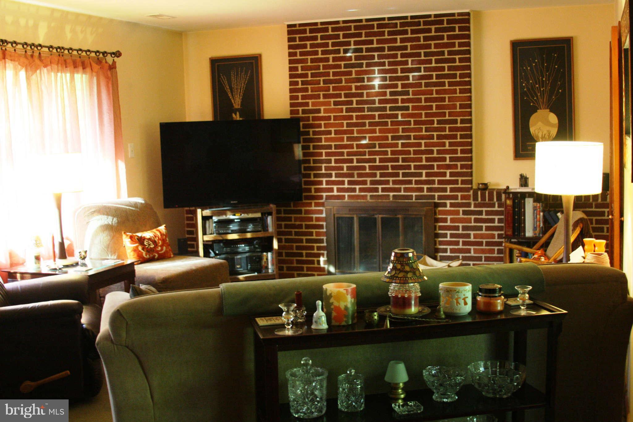 2419 Stoneybrook Road Fallston, MD 21047 - Photo 5 of 30 a living room with furniture a flat screen tv and a fireplace