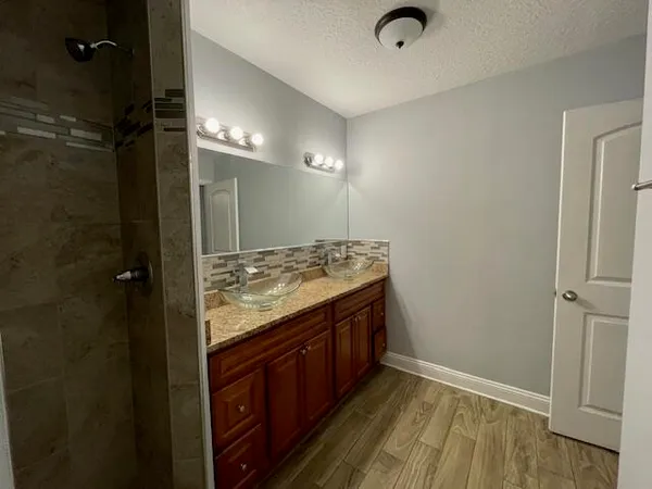 a bathroom with a granite countertop sink and a mirror