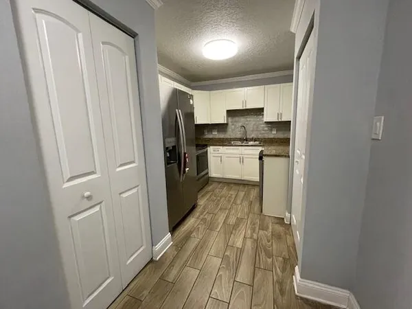 a kitchen with stainless steel appliances granite countertop a refrigerator and a sink