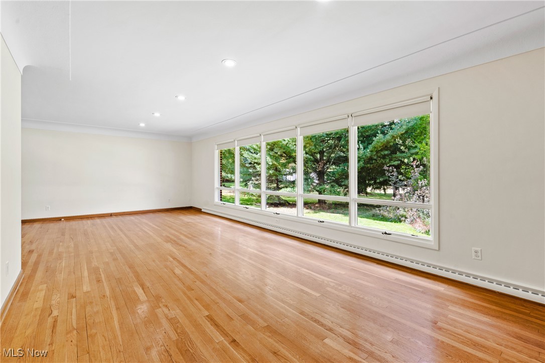 870 Trebisky Road Cleveland, OH 44121 - Photo 4 of 48 Spare room with a baseboard radiator, light hardwood / wood-style flooring, and plenty of natural light