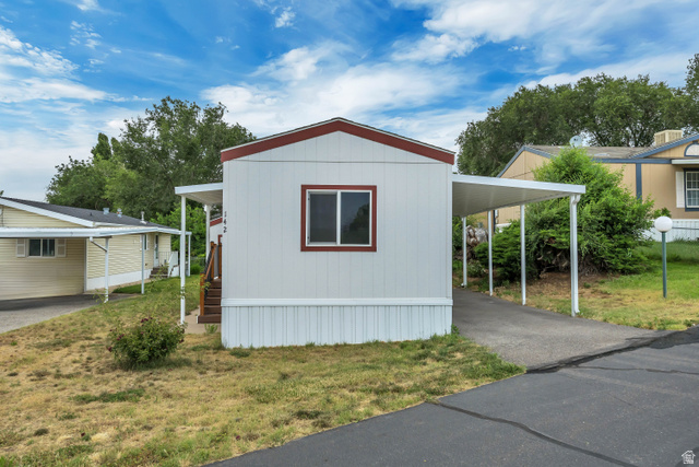 142 Cushing Way Layton, UT 84041 - Photo 14 of 15 White exterior with red trim featuring a single window and an attached carport