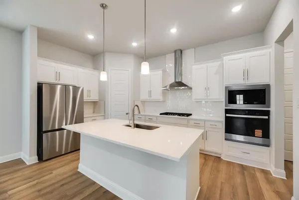 a kitchen with stainless steel appliances a refrigerator sink and microwave