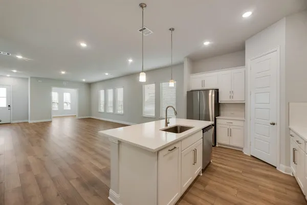 a kitchen with stainless steel appliances granite countertop a sink and a refrigerator
