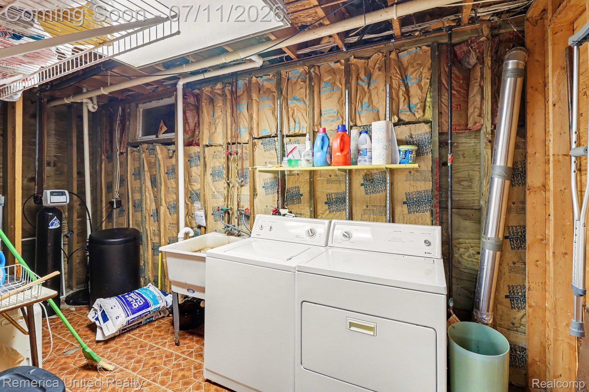 136 Endicott Howell, MI 48843 - Photo 24 of 28 Utility area featuring a laundry sink, washer and dryer, and tiled flooring