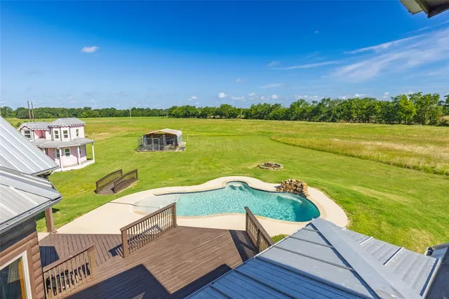 a aerial view of a house with swimming pool and a yard