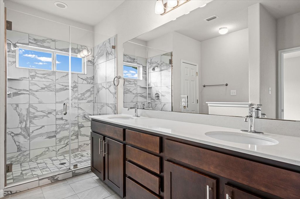 1012 Goldilocks Lane Manchaca, TX 78652 - Photo 14 of 38 Beautiful primary bath with double vanity, walk in shower and walk in closet.