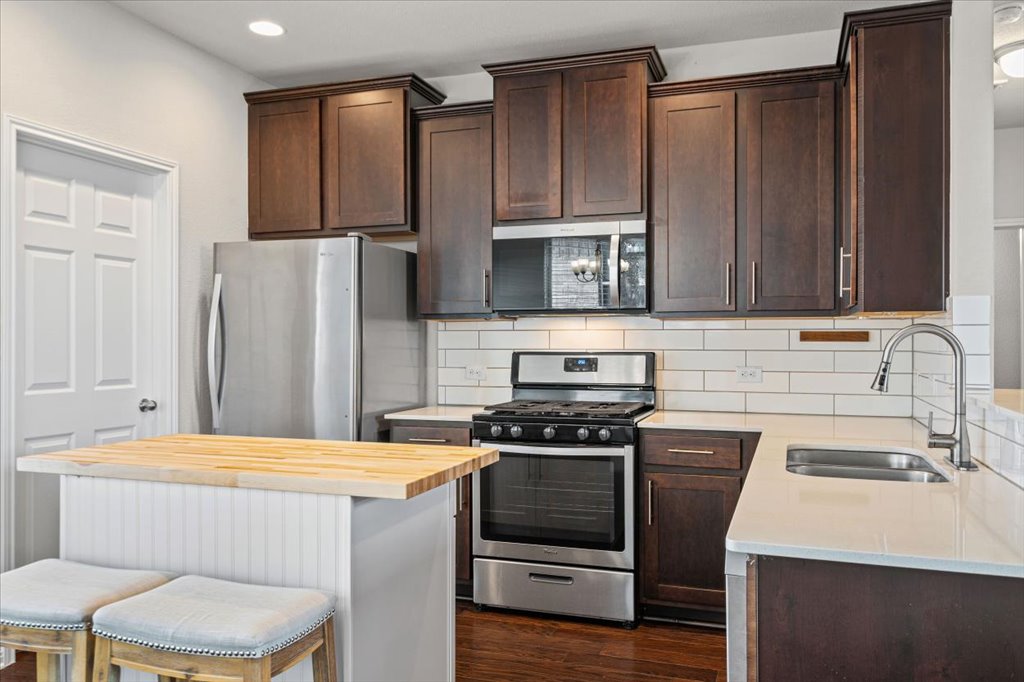 1012 Goldilocks Lane Manchaca, TX 78652 - Photo 6 of 38 Tile backsplash, stainless steel appliances, added island, and refrigerator included.