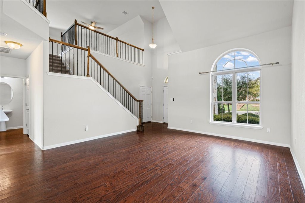 1012 Goldilocks Lane Manchaca, TX 78652 - Photo 8 of 38 Large living room with large windows, hardwood floors, ceiling fan, and high ceilings.