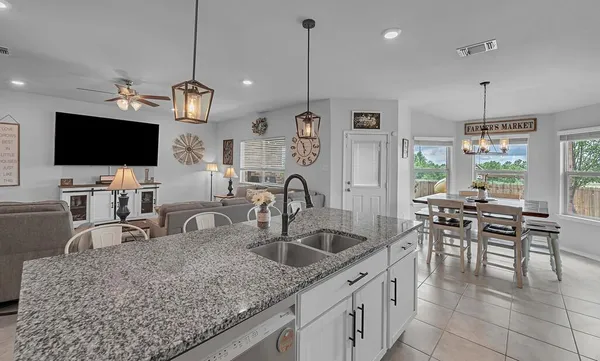 a kitchen with stainless steel appliances granite countertop a sink a stove and a wooden floors