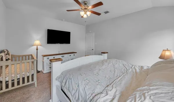 a bedroom with a bed and a flat screen tv