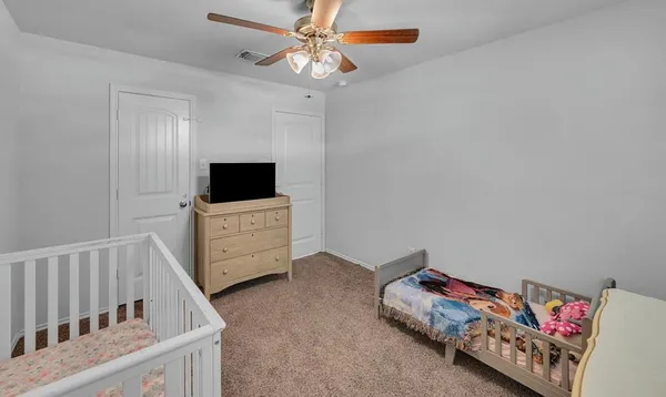 a living room with a baby crib furniture and a flat screen tv