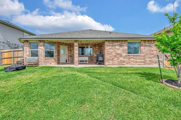 front view of a brick house with a yard